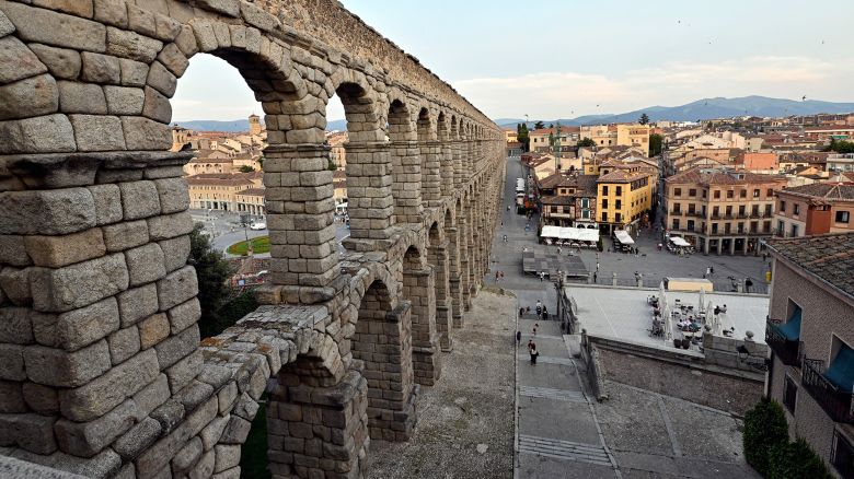 Tourists walk past the Aqueduct of Segovia, a Roman aqueduct in the Spanish city of Segovia in the Castilla and Leon region, on June 26, 2023. The Old Town of Segovia and the aqueduct were declared UNESCO World Heritage Sites in 1985. (Photo by OSCAR DEL POZO / AFP) (Photo by OSCAR DEL POZO/AFP via Getty Images)